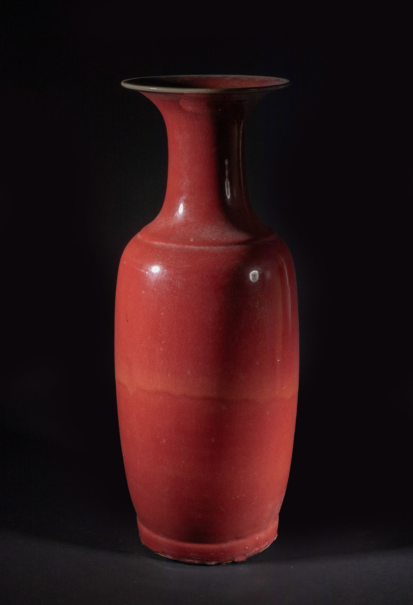 Tall Chinese Export Red Glazed Porcelain Vase: Of tall ovoid form rising from a short foot to a waisted neck with a flared rim, the exterior and interior neck applied in rick red glaze. Approx. 23.2*8 inch.