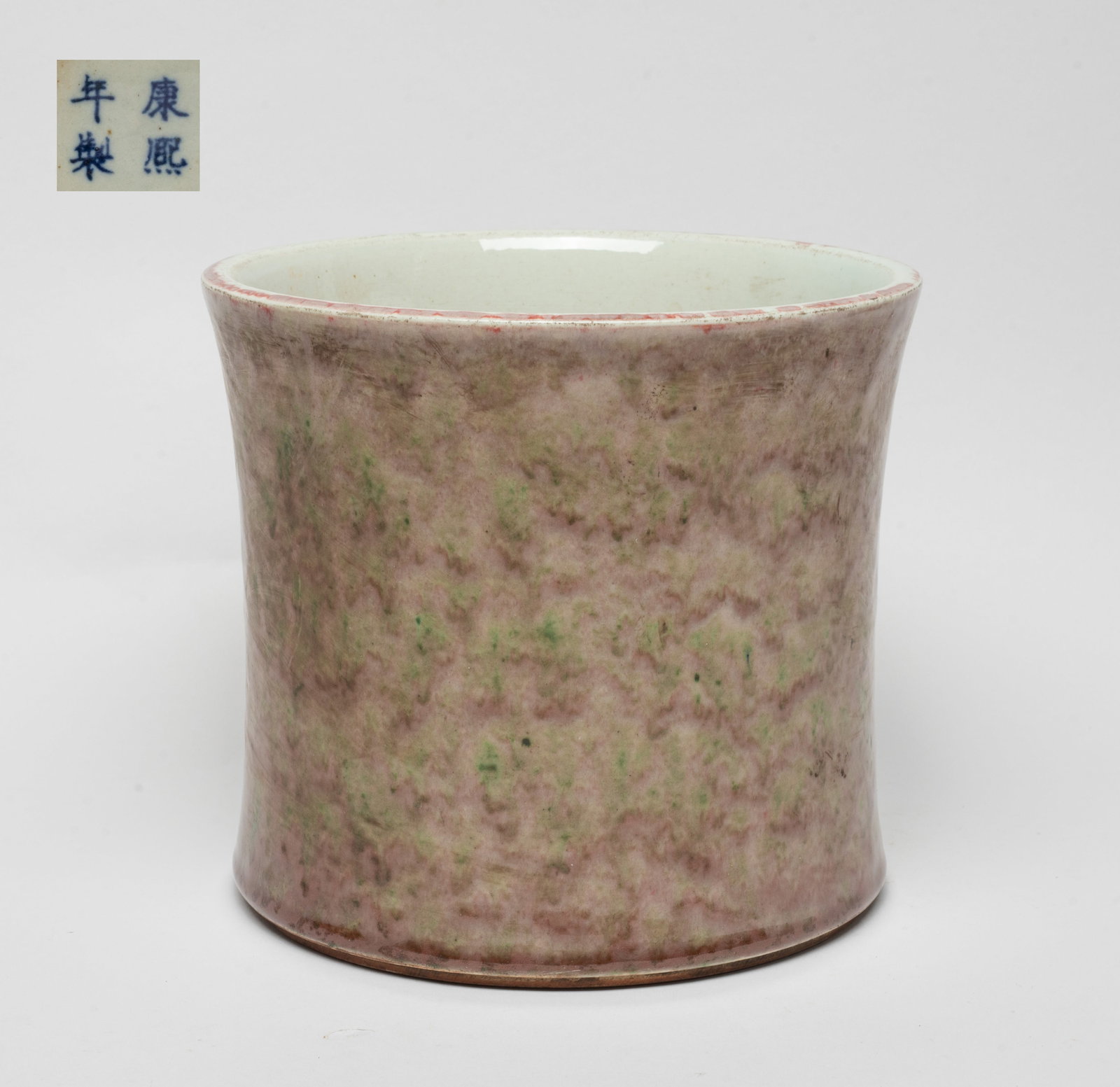 Chinese Flambe Glazed Porcelain Brush Pot: Of gently waisted cylindrical form, the exterior decorated with mottled pale red glaze with green inclusions, the bottom marked with four characters. Approx. 7.6*6.7 inch.