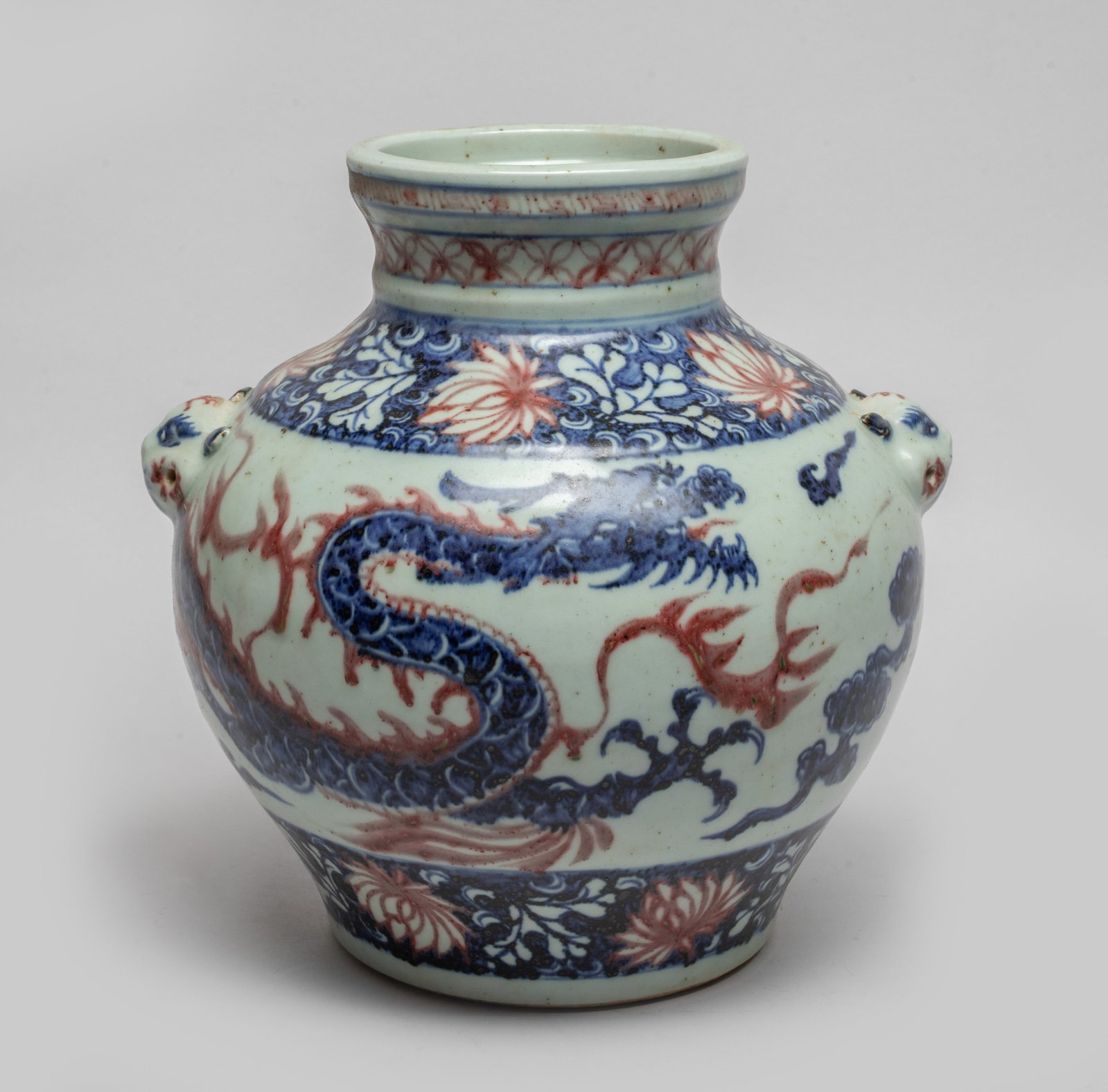 Estate Chinese Export Porcelain Vase: The ovoid body with a waisted neck, painted with a ferocious dragon amidst clouds, between bands of lotus foliage, set with a pair of raised beast masks. Approx. 9.7*9.5 inch.