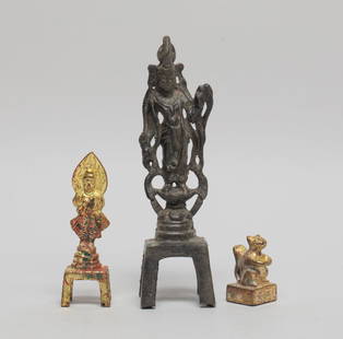 Set Chinese Gilt Bronze Sculptures: Including a Buddha cast standing on a waisted lotus base and a pedestal, the hands holding implements, a Buddha standing on a tall pedestal and wearing a flowing robe, and a seal cast with a squirrel
