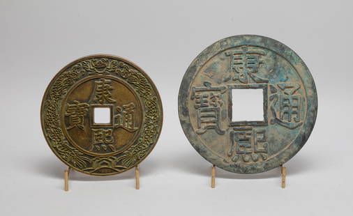 Two Chinese Export Large Bronze Sculptures: Two Chinese large bronze cast coin form sculptures, the smaller carved with a band of dragons along the rim, with stands. Approx. 6.5 inch D (larger w/o stand).