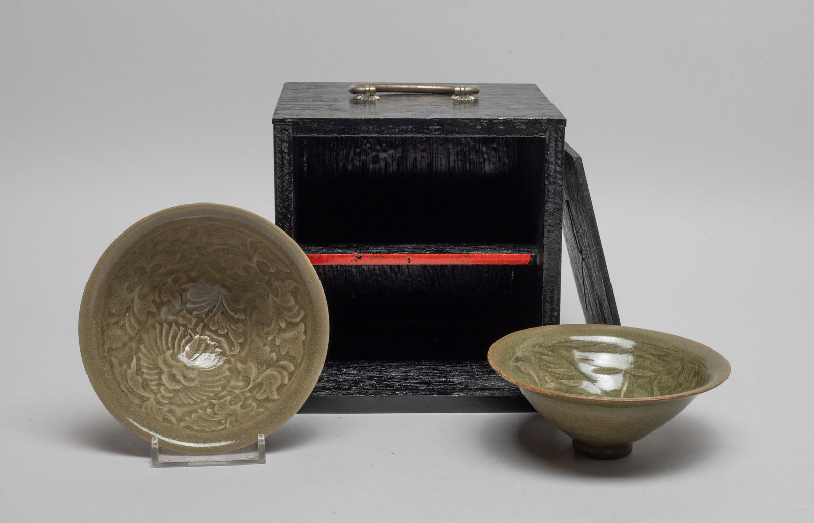 Chinese Yaochou Ware Porcelain Tea Cups: Both cups of conical form with gently flared rim, wherein one cup interior carved with floral foliage, the other interior carved with cranes and reeds, overall covered in crackled celadon glaze, with