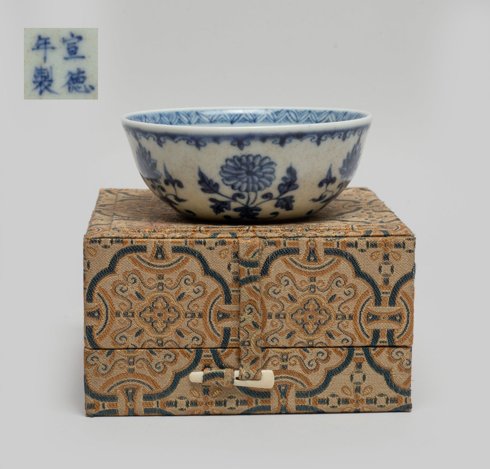 Estate Chinese Export Porcelain Tea Cup: The bowl interior centre decorated with a beribboned traditional symbol, the exterior with lotus, the bottom marked with four characters, with box. Approx. 3.4*1.3 inch. The Estate of the Store Closed