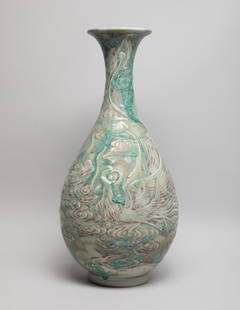 Chinese Flambe Glazed Porcelain Vase: The pear-shaped body rising from a short foot to a waisted neck and a flared rim, the exterior carved with a phoenix with outstretched wings and a long curled tail amidst scrolling clouds, the exterio