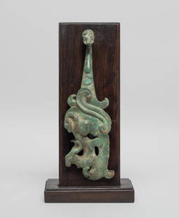 Collectible Chinese Bronze Belt Buckle on Stand: Cast in the form of a sinuous dragon, the serpentine body in profile undulating with ribbon-like fins, the tail end issuing a hook of dragon head form, with stand. Approx. 8.5*4.2*2.1 inch (w/ stand).