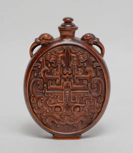 Large Chinese Boxwood Snuff Bottle: Of flattened ovoid form, flanked by a pair of beast head handles, either side carved with a taotie mask below a pair of archaistic dragons, with a matched stopper. Approx. 5.1*3.7*1.3 inch.