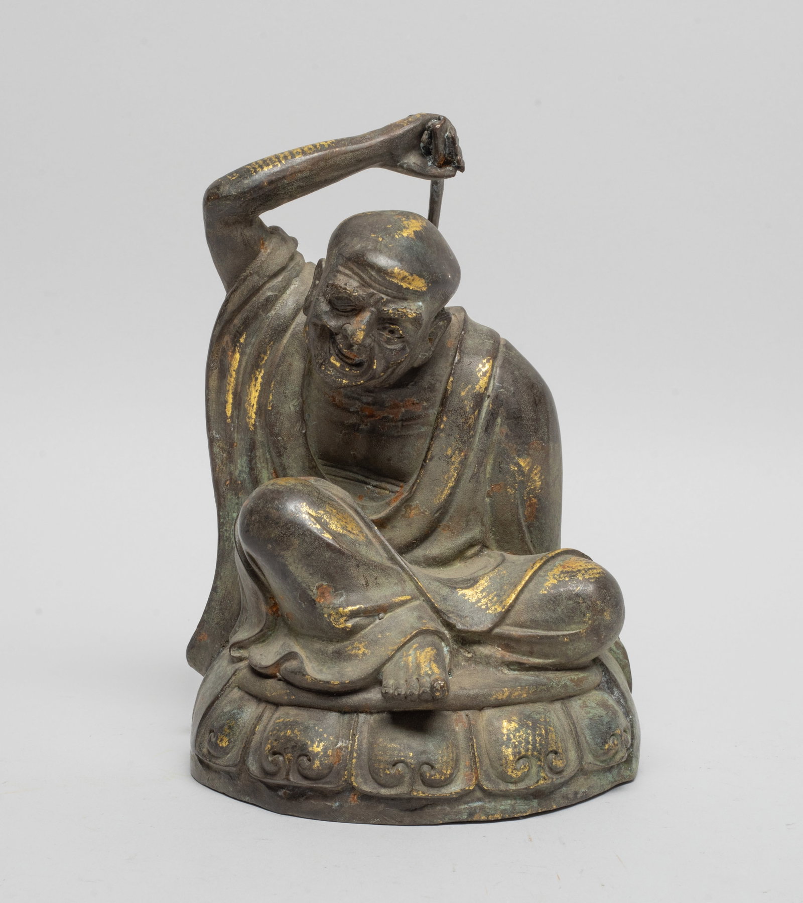 Chinese Painted Bronze Sculpture of Buddha: The Buddha cast seated on a lotus base, his right hand holding a stick scratching his back. Approx. 6.6*4.5*3.5 inch.