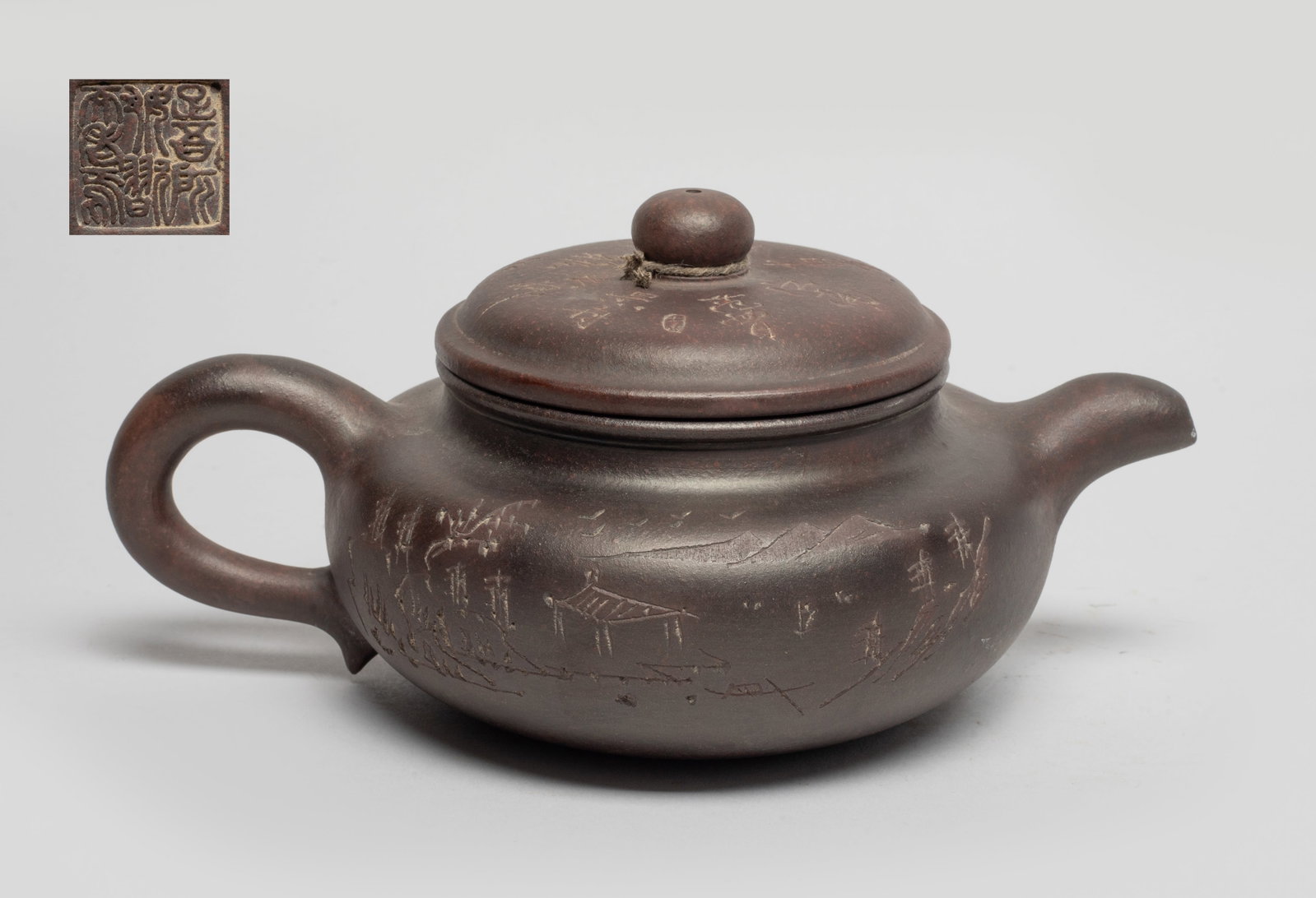 Chinese Yixing Zisha Tea Pot: The tea pot body incised with landscape scene and inscribed with related passages, the bottom inscribed with a six-character mark. Approx. 7.7*5.2*3.6 inch.