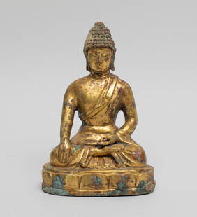 Estate Chinese Gilt Bronze Sculpture of Buddha: The Buddha cast seated on a lotus throne, his left hand in karana mudra and right hand in bhumisparsa mudra, wearing a loose-fitting robe open at the chest revealing the right arm, the meditative face