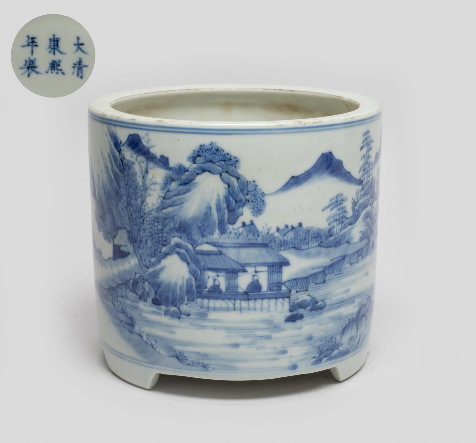 Chinese Blue & White Porcelain Censer: Of cylindrical form with three short feet, the exterior painted with a continuous scene depicting a mountainous river landscape, on the foreground with three figures standing on the shore and two figu