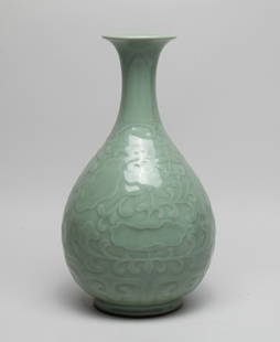 Large Chinese Longquan Porcelain Vase: The pear-shaped body rising from a to a waisted neck with a flared rim, the exterior carved with lotus scrolls above a band of petals, overall covered with celadon glaze. Approx. 11.7*6.5 inch. The Es