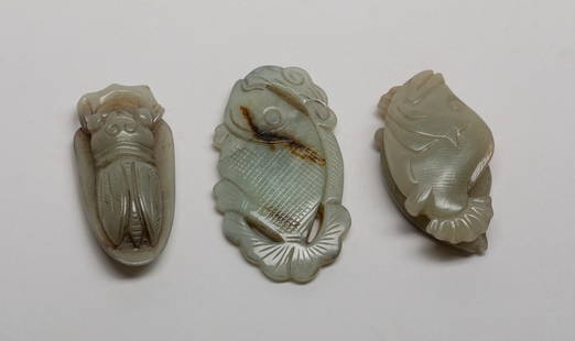 Set Chinese Russet Jade Pendants: Set of three russet jade pendants, one carved as a cicada on a leaf, one as a fish holding a long stem, the other as two fish close to each other. Approx. 2.65*1.5 inch (largest).