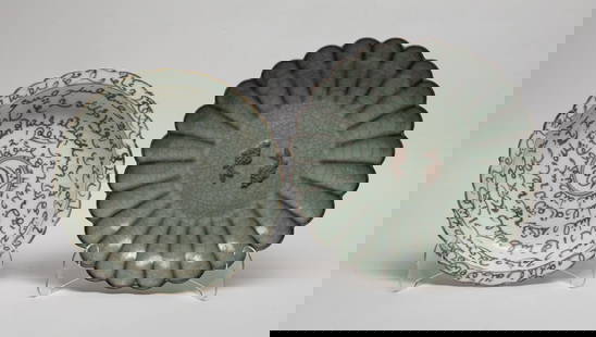 Two Chinese Export Porcelain Plates: One plate of floral form, overall covered with crackled gray glaze, the interior centre carved with a pair of raised unglazed fish, the other plate decorated with mythical pattern around the inside an