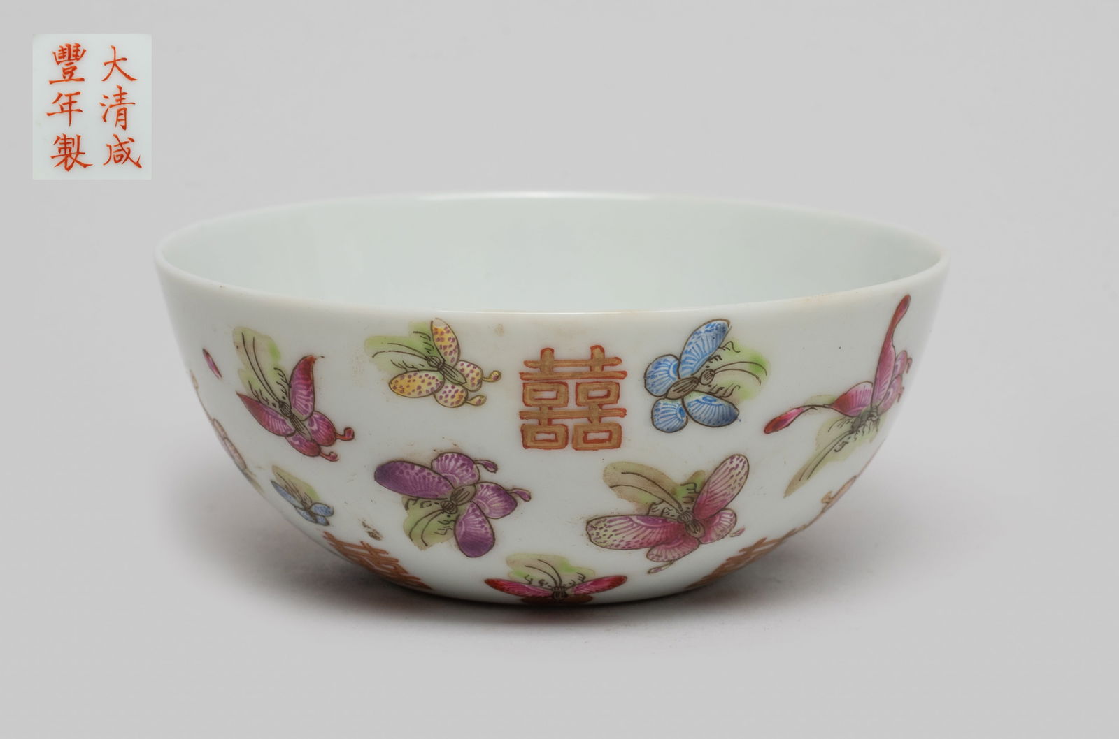 Chinese Famille Rose Porcelain Tea Cup: The tea cup exterior enameled with butterflies and double happiness symbols, the bottom marked with six characters in copper red. Approx. 3.5*1.5 inch.