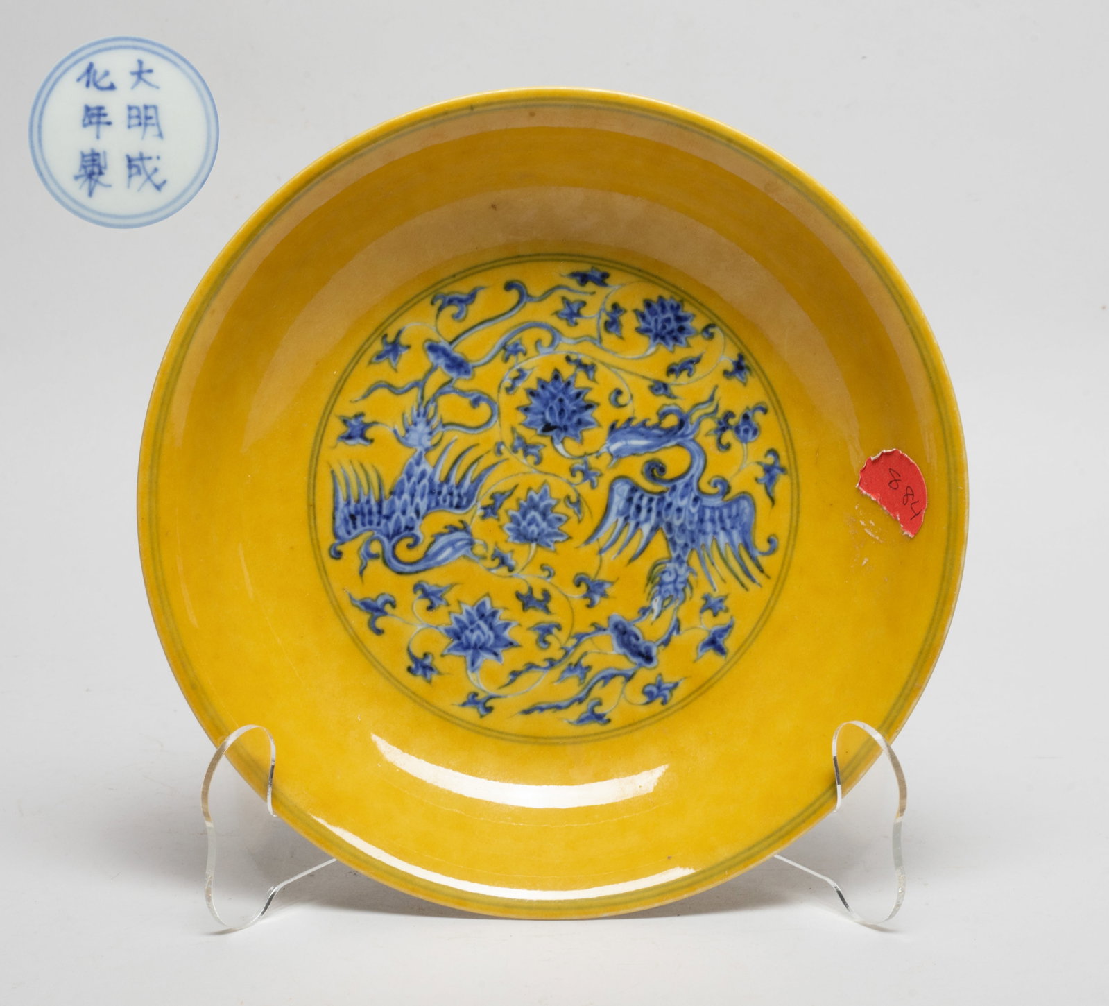 Chinese Export Porcelain Plate: The plate interior centre and exterior painted in cobalt-blue with phoenixes amidst leafy sprays issuing lingzhi and lotus, against yellow-glazed background, the bottom marked with six characters encl