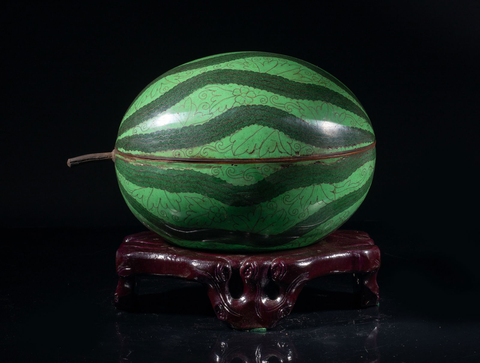 Chinese Cloisonne Watermelon Sculpture: Collectible Chinese cloisonne watermelon sculpture, the exterior ecorated with stylized flower motif, the interior applied with turquoise blue glaze, with a wood stand carved in craggy branch form. Ap