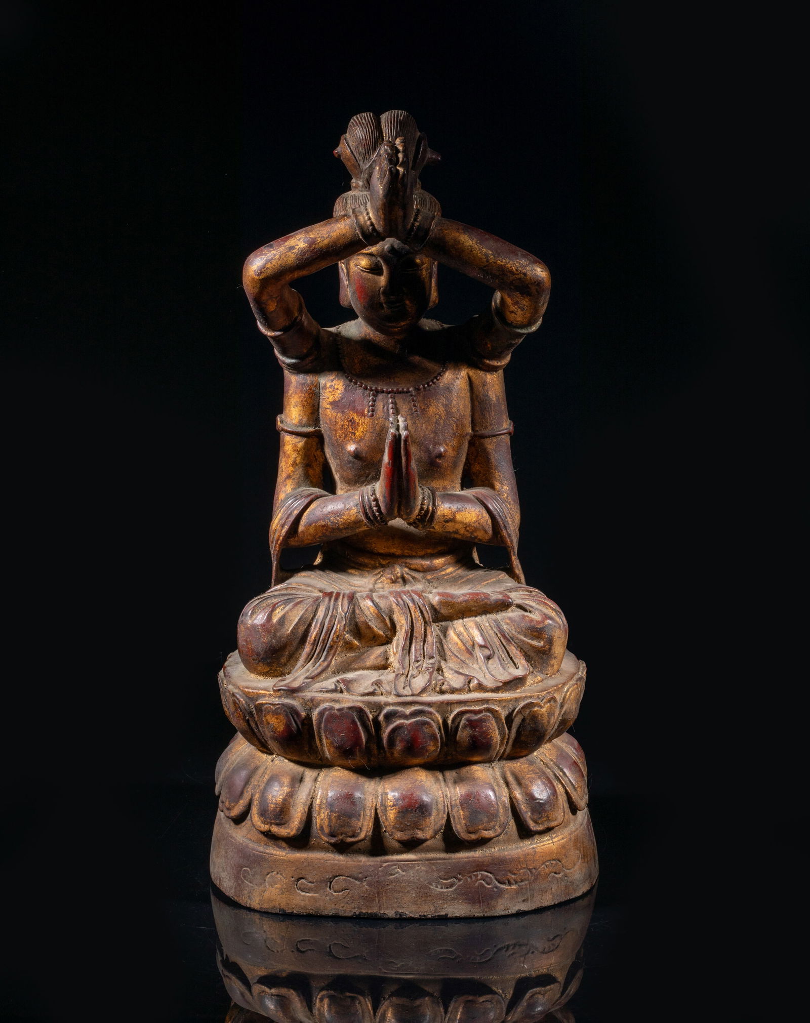 Large Chinese Gilt Wood Sculpture of Buddha: The Buddha carved seated on a waisted lotus throne, the front pair of arms raising up with hands in namaskara mudra, the rear pair of hands in namaskara mudra in front of chest, the combed hair piled