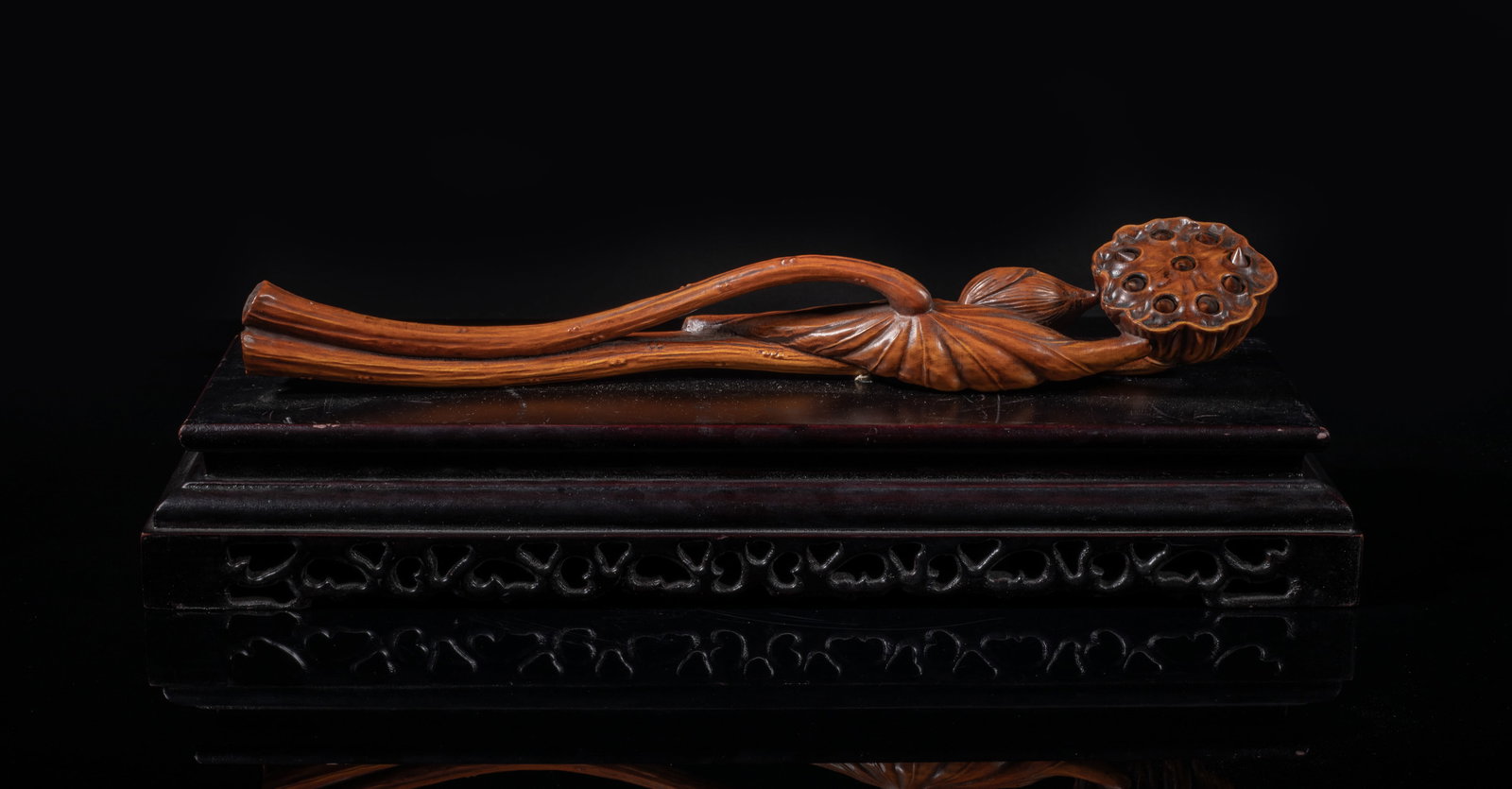 Chinese Boxwood Sculpture of Ruyi: Carved in the form of three parallel stems, one terminating in a veined lotus leaf wrapping the other two stems below a blooming lotus bud and lotus pod enclosing four separately carved lotus seeds, a