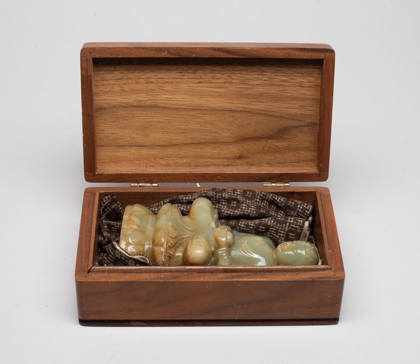 Chinese Export Russet Jade Buddha: Seated in dhyanasana on a waisted lotus throne, with both hands in a meditational mudra and holding a bowl, the flowing robes with long sleeves layered over a dhoti, the face with peaceful expression,