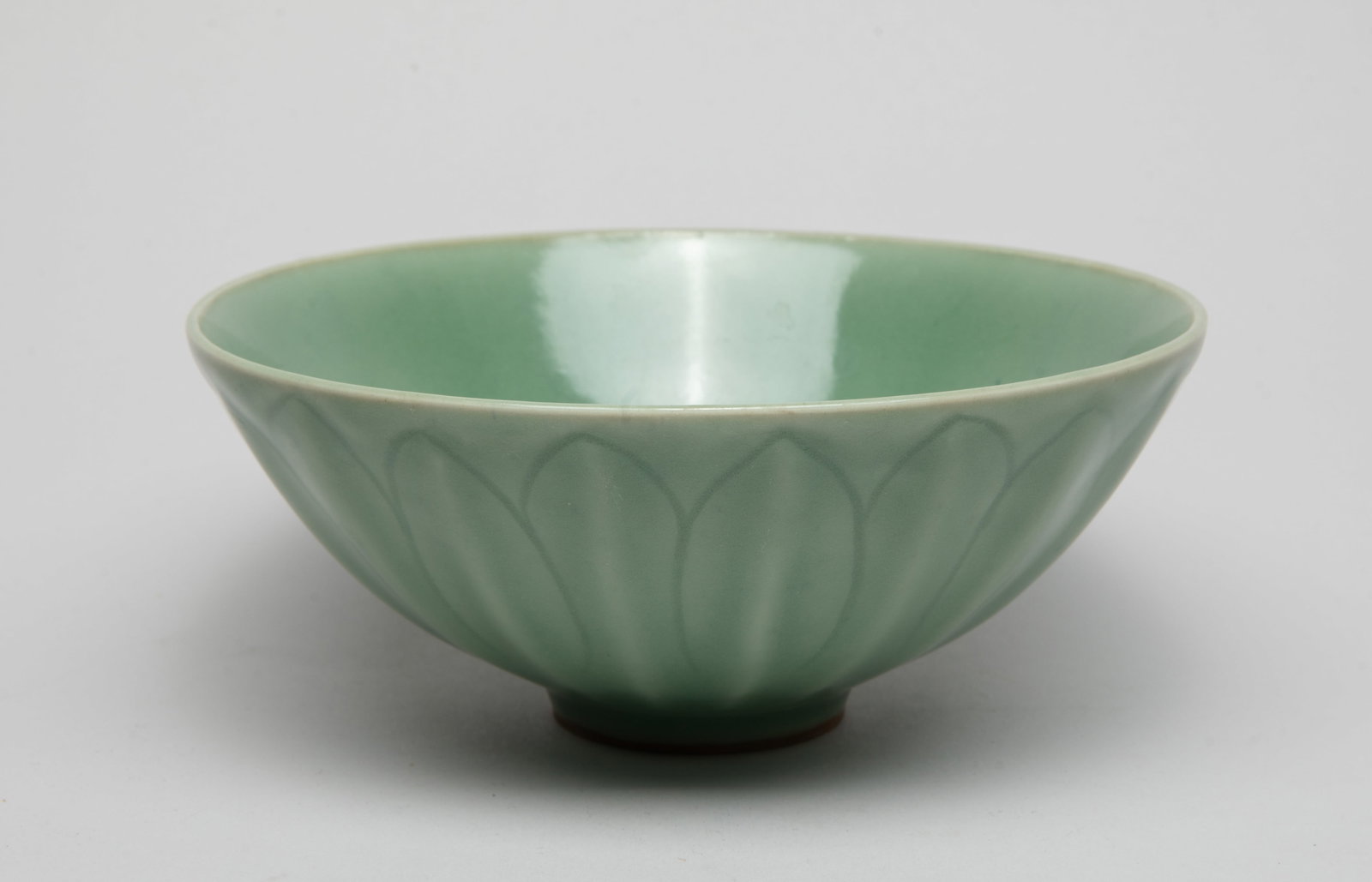 Large Chinese Longquan Porcelain Bowl: The bowl exterior carved with upright overlapping petals, overall covered with celadon glaze. Approx. 6.8*2.8 inch.