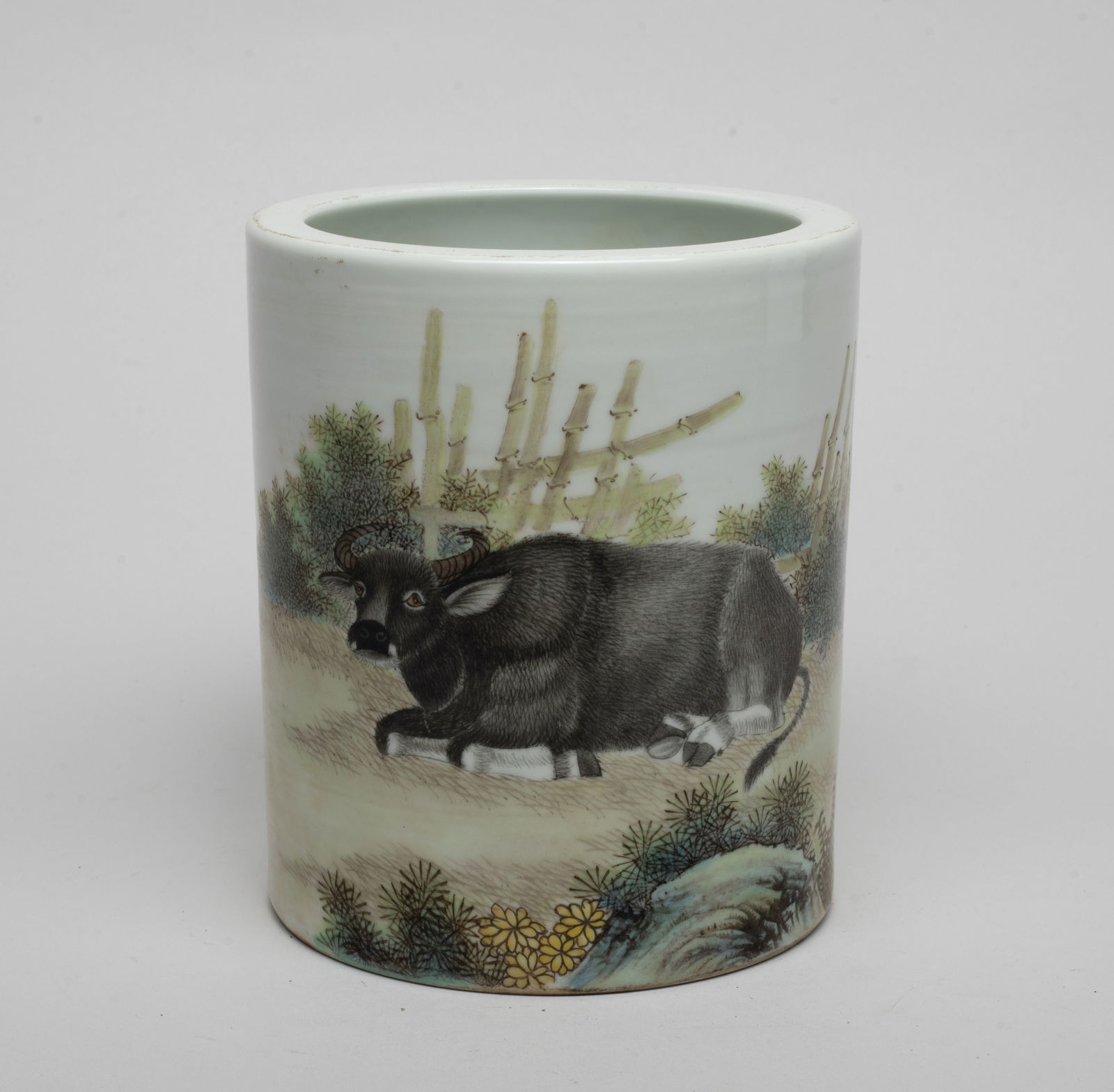 Chinese Famille Rose Porcelain Brush Pot: Of cylindrical form, the exterior painted with a cattle recumbent on ground among flowers and scrubs, inscribed with related passages. Approx. 5.7*5 inch.