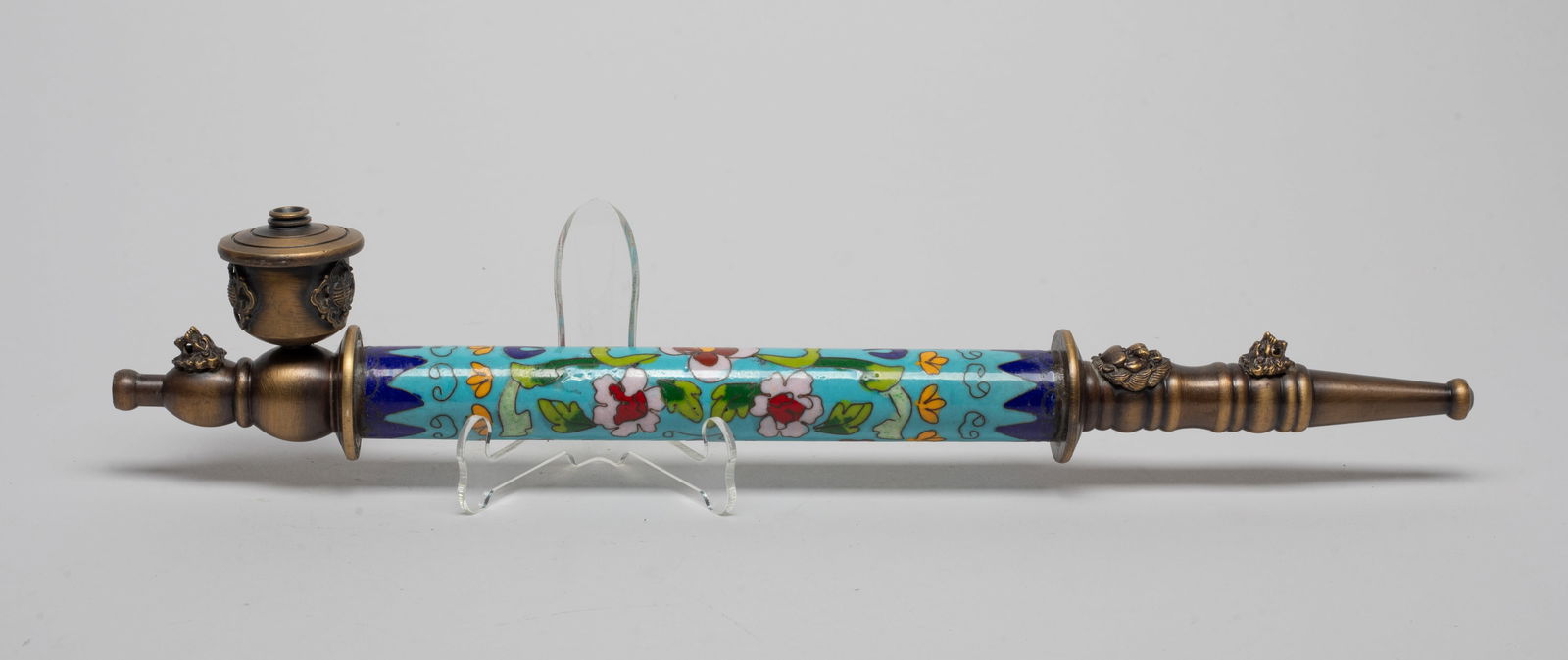 Estate Chinese Cloisonne Pipe: The cloisonne body enameled with flowers on turquoise-blue background, the mouth cast with raised masks, the front cast in double gourd form with traditional symbols and a mask. Approx. 14.6*2.7*1.5 i