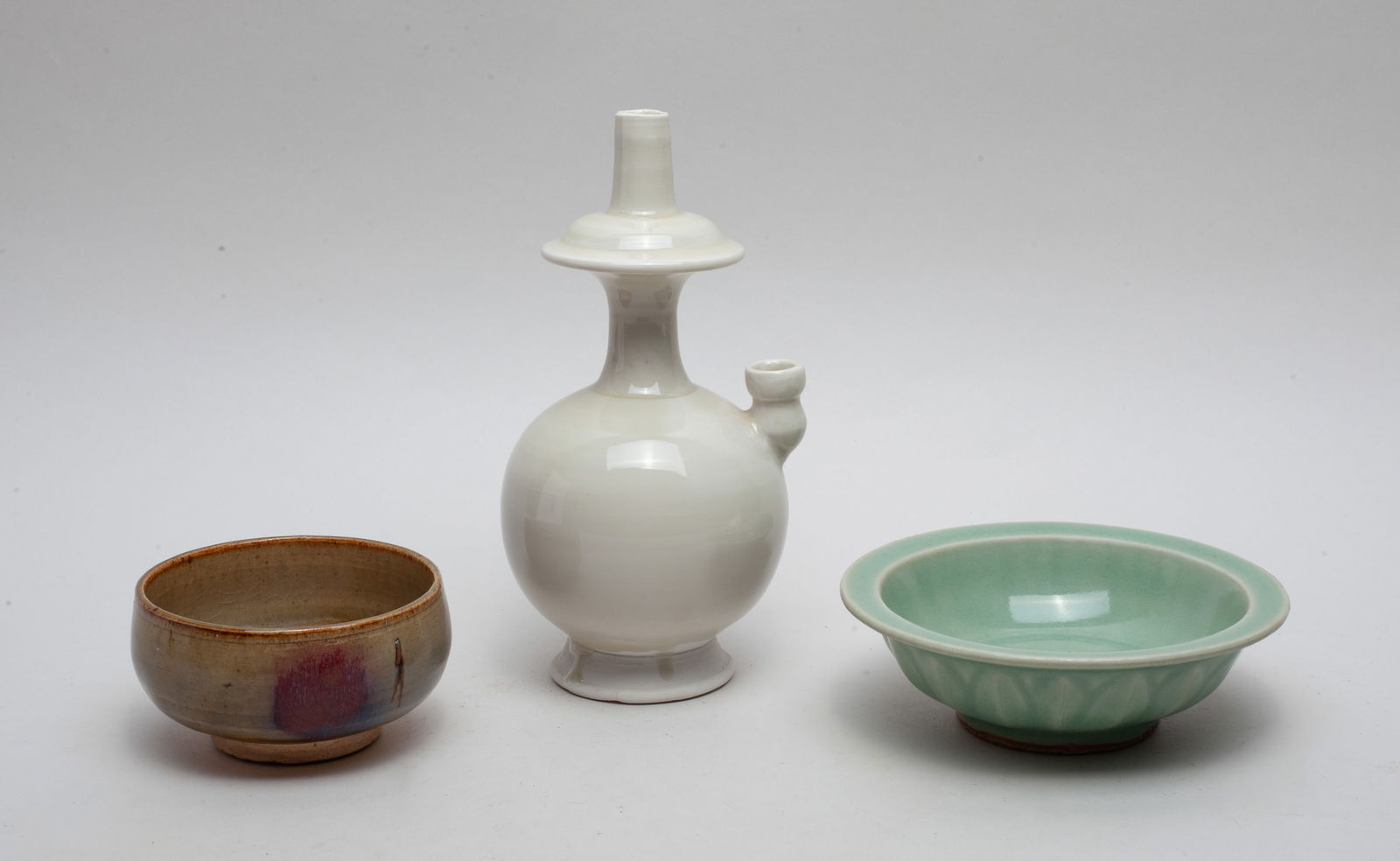 Three Chinese Export Porcelains: Estate Chinese porcelains, three as a lot, including a Ding type porcelain vase; a Jun type porcelain tea cup; a Longquan type porcelain deep dish. Size Approx.: 7.25-3.4-3.4 inch. (largest).