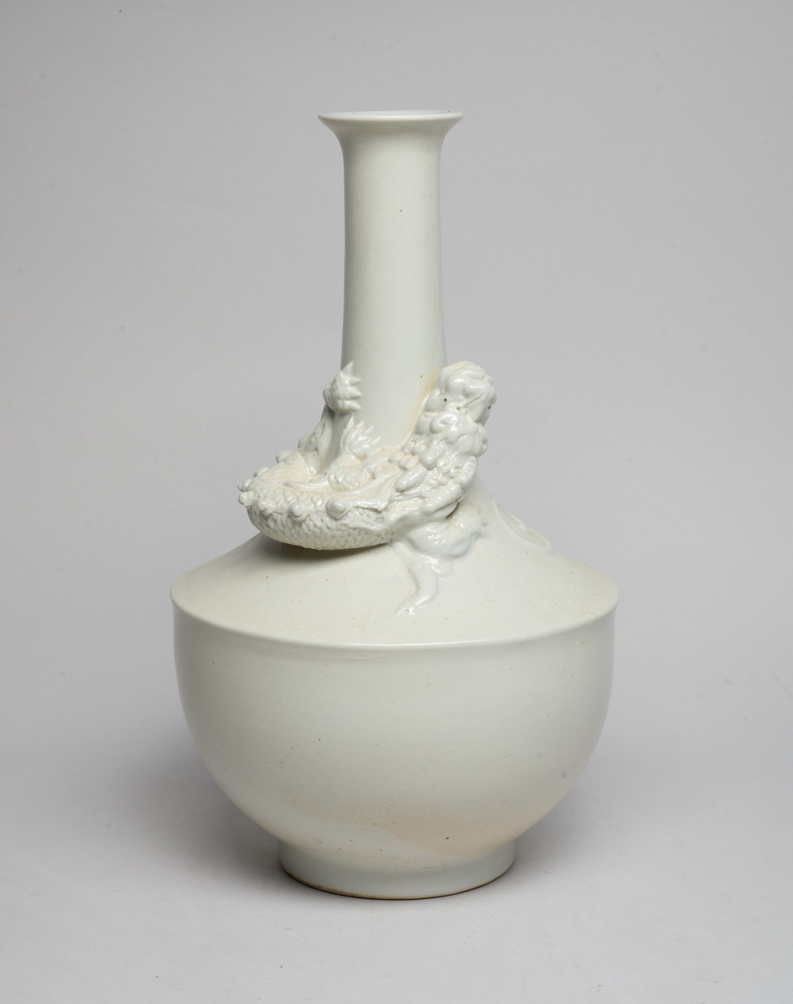 Estate Chinese Cream Glazed Porcelain Dragon Vase: Carved in high relief with a dragon sinuous around the neck, with scaly body and bifurcated tail, overall covered with creamy white glaze. Approx. 11.1*6.3 inch.