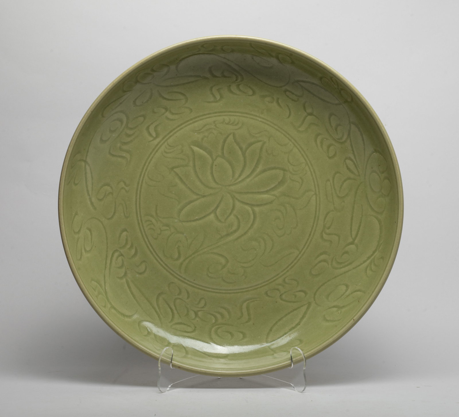 Large Chinese Longquan Porcelain Charger: The charger inside and out carved in low relief with lotus and meandering foliage sprays, covered with celadon green glaze. Approx. 15*2.7 inch.