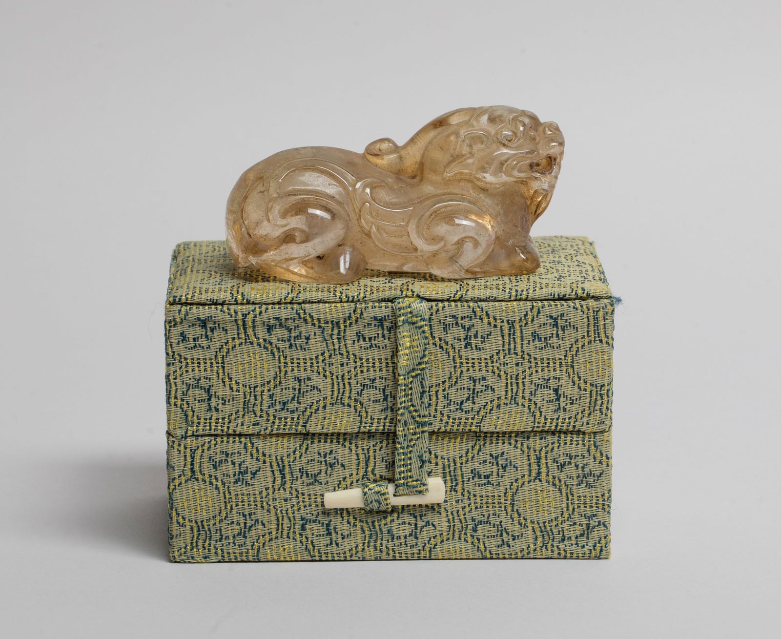 Vintage Chinese Rock Crystal Beast: Carved in recumbent single-horned beast form, the legs tucked under its body, the mouth open baring its teeth, drilled through the mouth, with box. Approx. 2.8*1.35*1.35 inch (beast size). The Estate