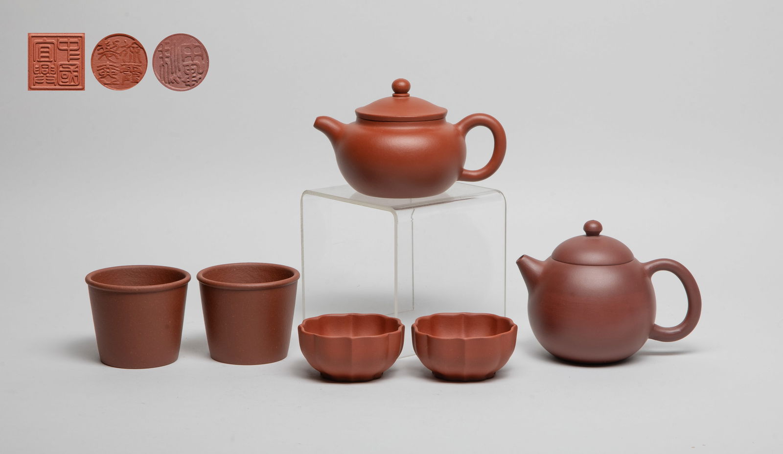 Chinese Yixing Zisha Tea Pot & Cups: Including four zisha tea cups, each bottom incised with a seal mark, and two zisha tea pots, each inscribed with a circular mark on the bottom, and two marks on the lid interior. Approx. 4.8*3.7*3.3 i