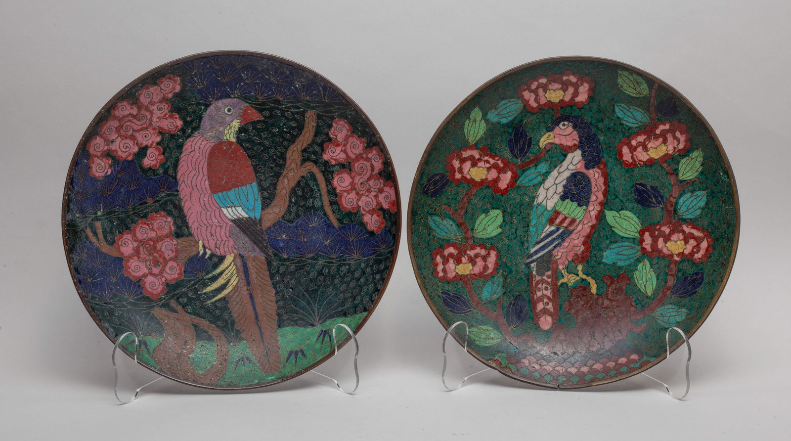 Pair Japanese Edo Cloisonne Plates: Each plate interior enameled with a bird on flower tree, the exterior with flowers or clouds, all against dark green ground. Approx. 9.7inch D (each).