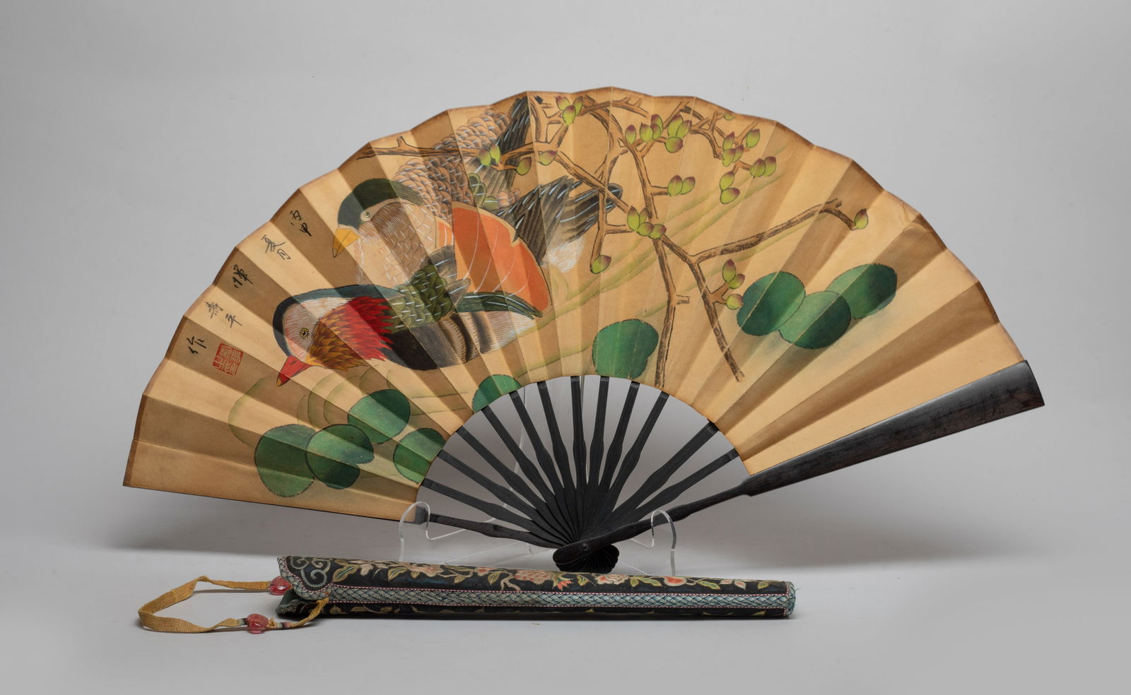 Chinese Water Color Fan Painting w/ Case: The fan painted on one side with two birds under leafy tree branches, the reverse inscribed with poems, with a silk case embroidered with flowers. Approx. 24*13 inch (fan size). The Estate of the Stor
