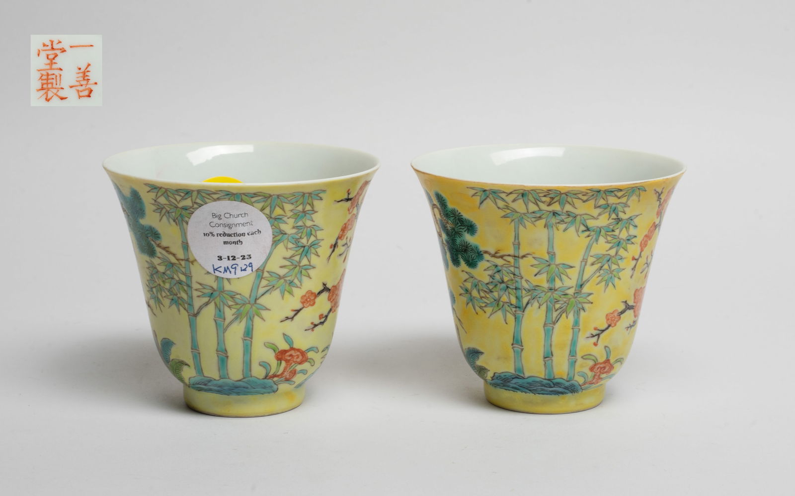 Pair Chinese Famille Rose Porcelain Tea Cups: Each tea cup exterior enameled and painted with pine tree, plum blossom tree, bamboo and lingzhi, on yellow background, the bottom marked with four characters in copper-red. Approx. 3.35*3 inch (each)