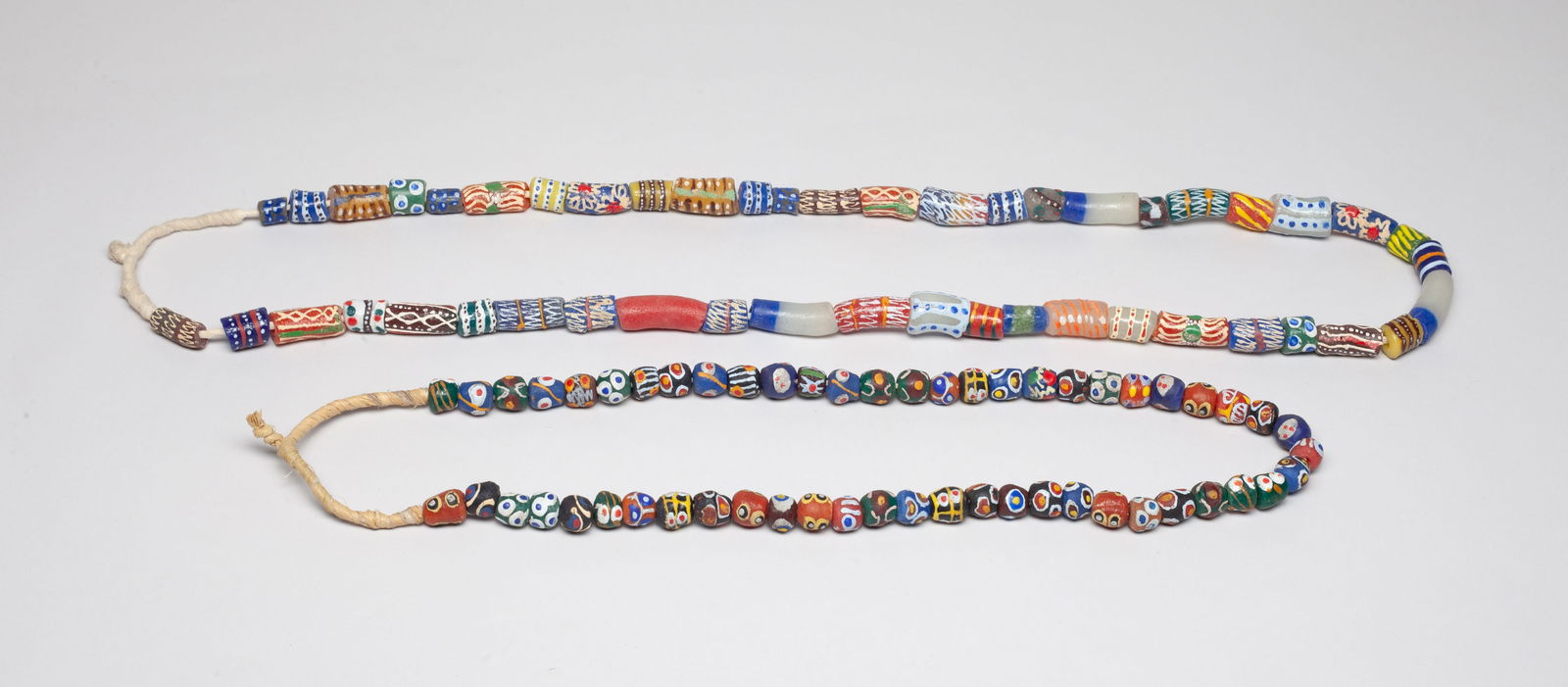 Ghanaian Trade Eye, Banded Glass Beads: Two Ghanaian trade colorful banded glass bead necklaces. Approx. 40 inch L.