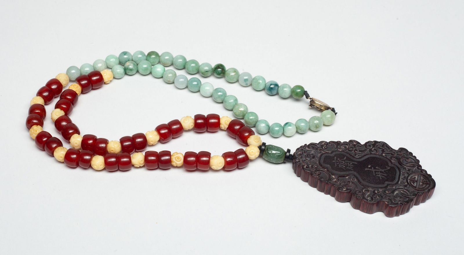 Chinese Lg Plaque w/ Agate, Stone, Mixed Necklace: Chinese agate, stone, and bone carved bead necklace, with a wood / bamboo like plaque, carved with a bat and a shou character among interlocking scrolls, either side inscribed with two characters. App