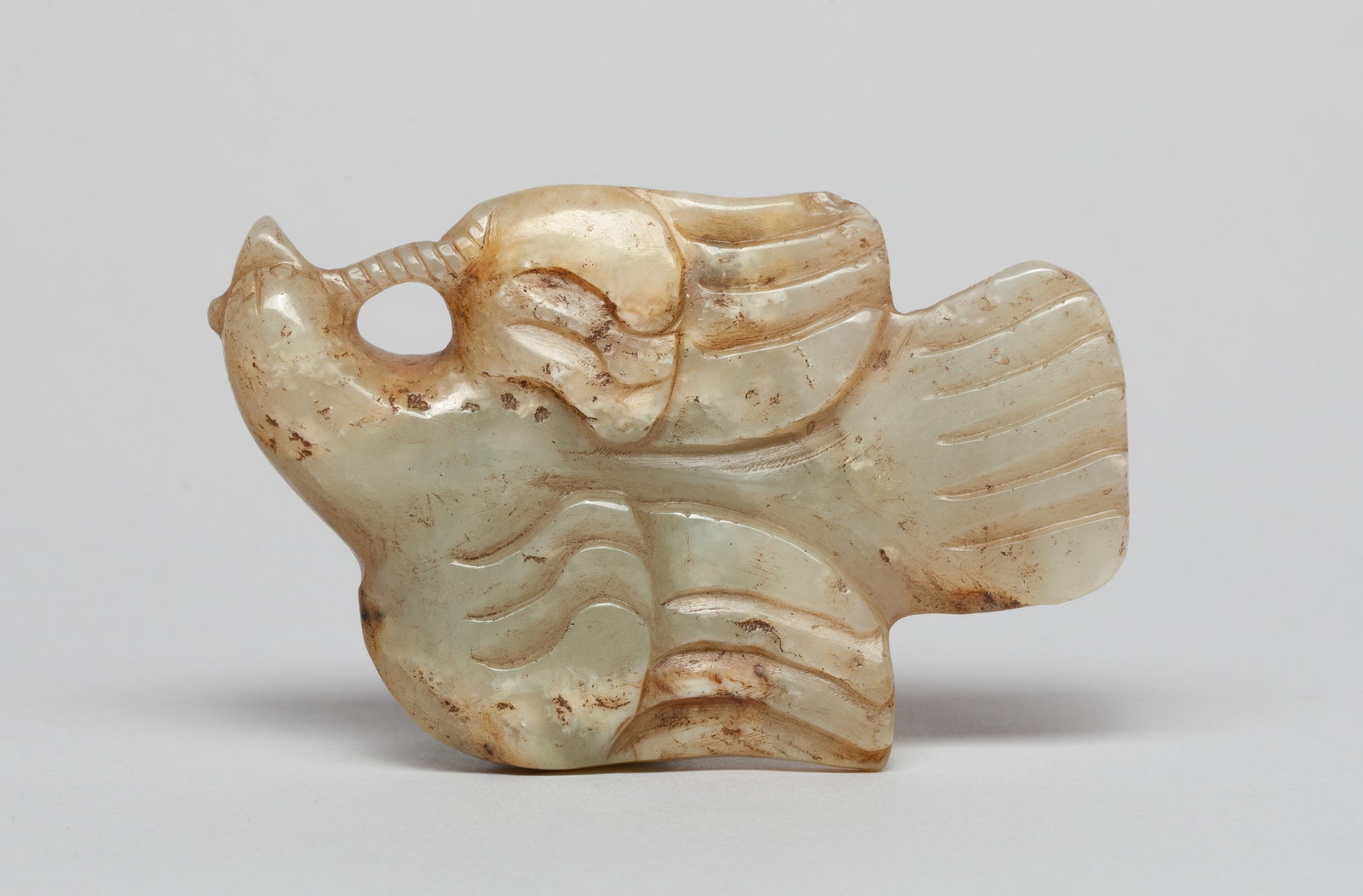 Chinese Russet Jade Bird Pendant: Chinese russet jade pendant carved in bird form, the beak carrying a worm forming an aperture for suspension. Approx. 2.85*1.85 inch.