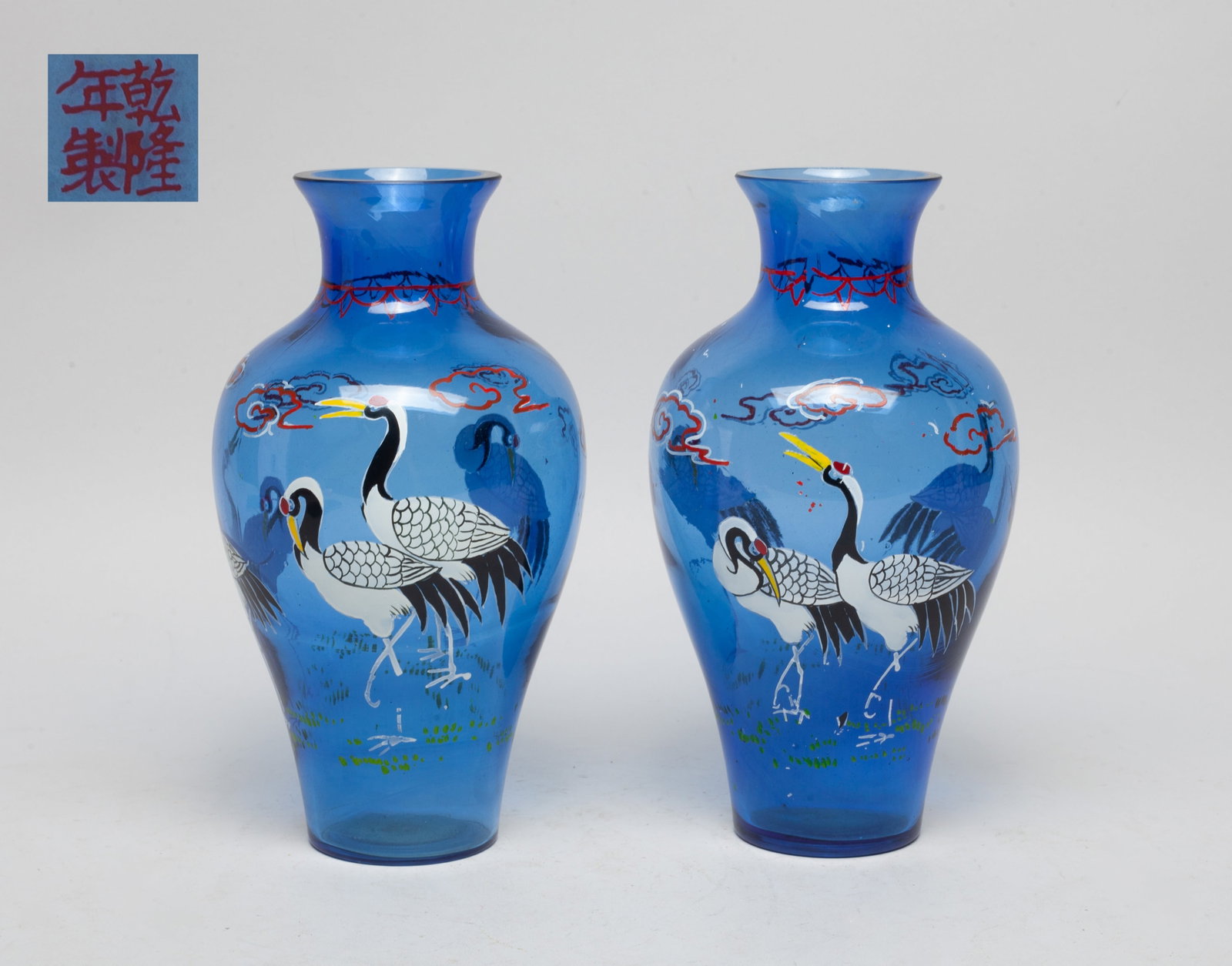 Two Chinese Enameled Peiking Glass Vases: Two clear blue Peiking glass vases, enameled and painted with cranes flaying among clouds, the bottom inscribed with a four-character mark. Approx. 7.9*4.3 inch (each).