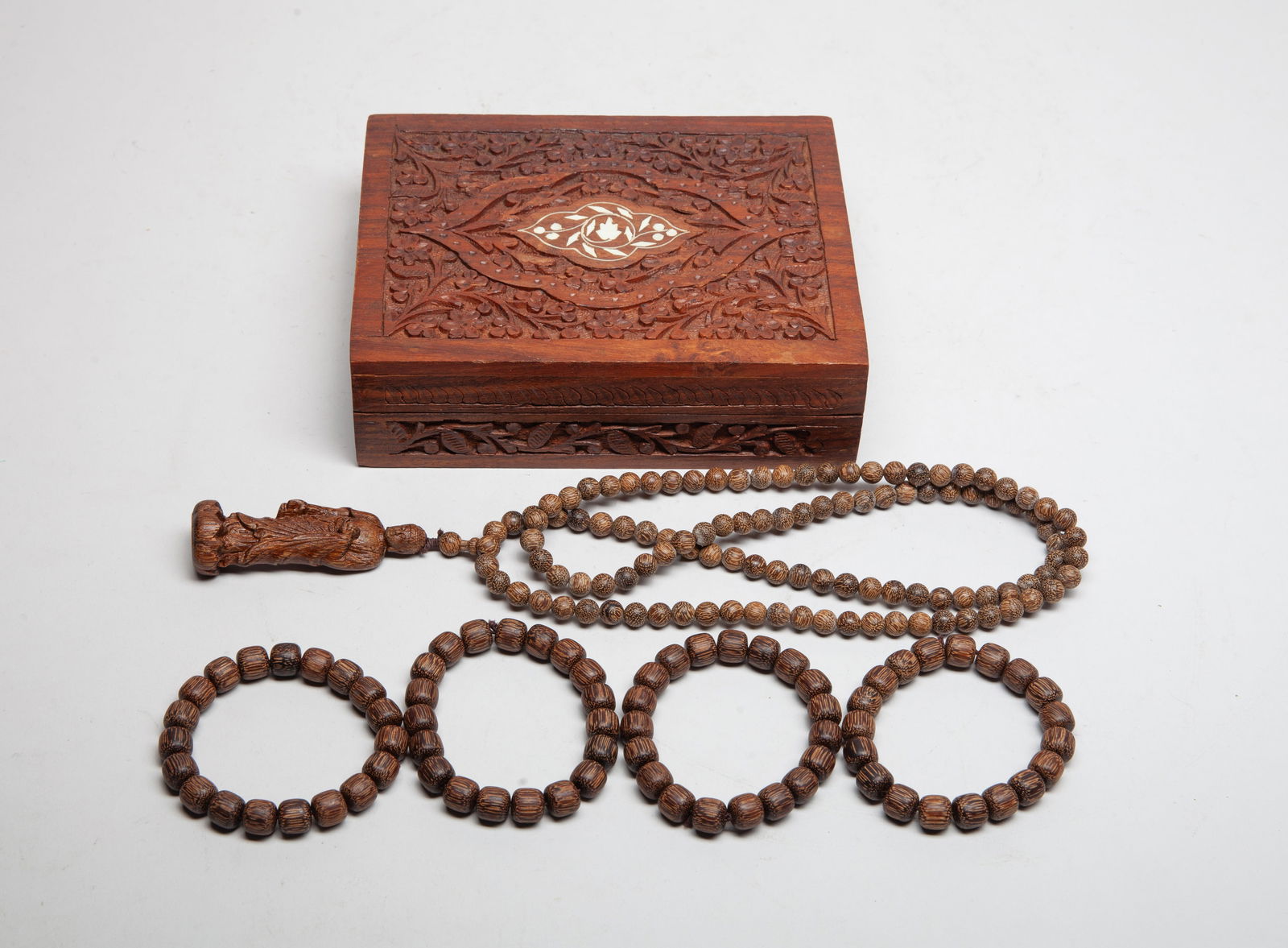 South Asian Agarwood Beads Necklaces: Including four agarwood bead bracelets, and a long bead necklace with an agarwood Buddha pendant, the wood slightly fragrant, with box. Approx. 100 gram (total wood weight), 34 inch L (necklace size).