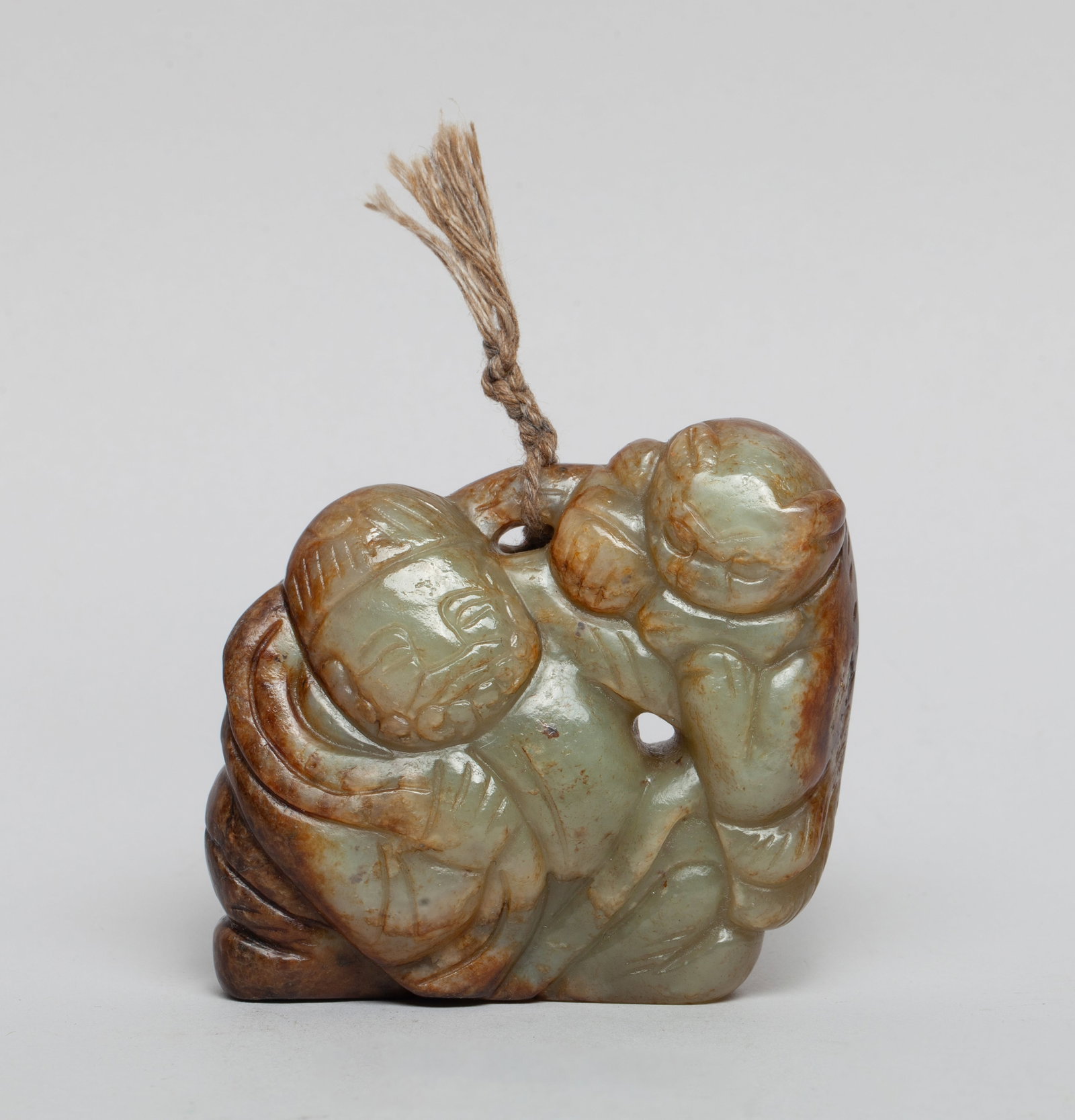 Estate Chinese Russet Jade Pendant: Chinese pale celadon and russet jade pendant, carved as a cat clambering on the figure's left arm, his right hand carrying the cat's tail. Approx. 2.67*2.35*0.9 inch.
