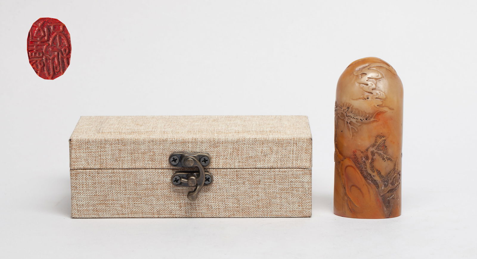 Estate Chinese Shoushan Stone Seal: Chinese russet Shoushan stone seal, the body carved with a scholar walking on a bridge in landscape, inscribed, with box. Approx. 3.4*1.45*1 inch (w/o box).