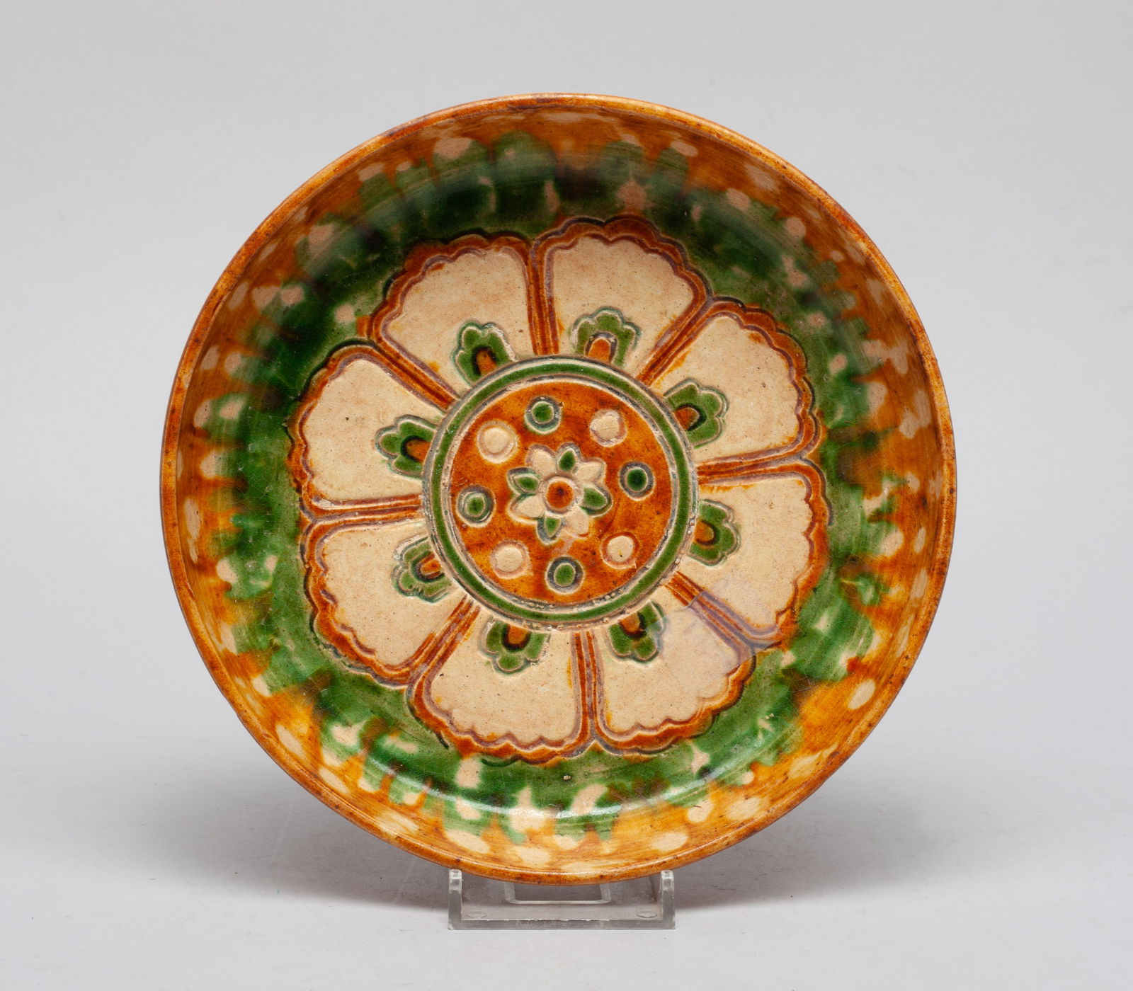 Chinese Sanchai Stoneware Deep Plate: The plate interior carved with a large flower bloom, applied with creamy, brown and green glaze, save for the unglazed bottom. Approx. 6.9*1.5 inch.