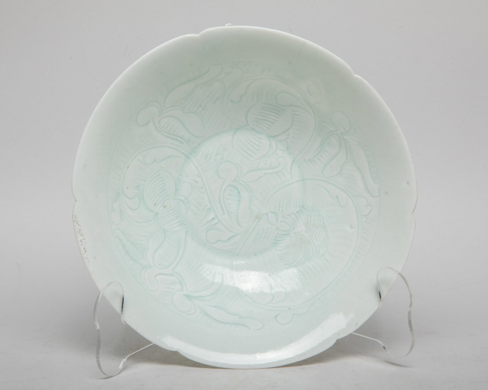 Estate Chinese Hutian Porcelain Deep Bowl: The bowl interior carved in low relief with stylized blossoming flowers, overall covered with crackled pale sea green glaze. Approx. 7.5*2.4 inch.