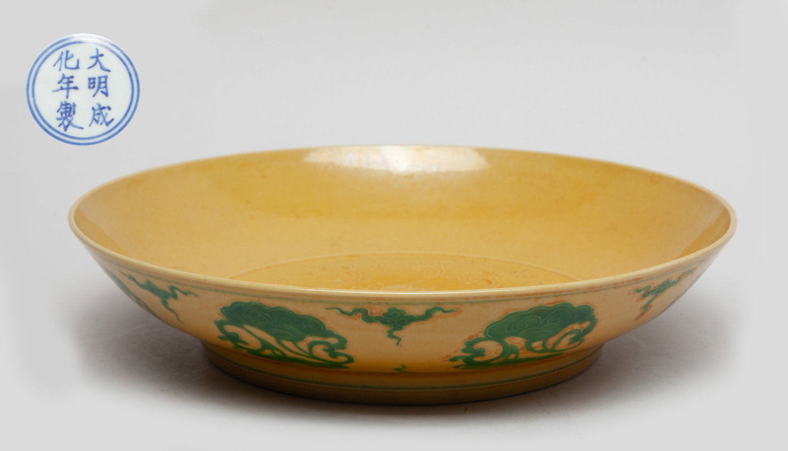 Chinese Yellow Glazed Porcelain Plate: The plate interior centre decorated with lotus scrolls and Buddhist symbol, the exterior enameled with lingzhi scrolls in green glaze, all against yellow glazed ground, the bottom marked with six char