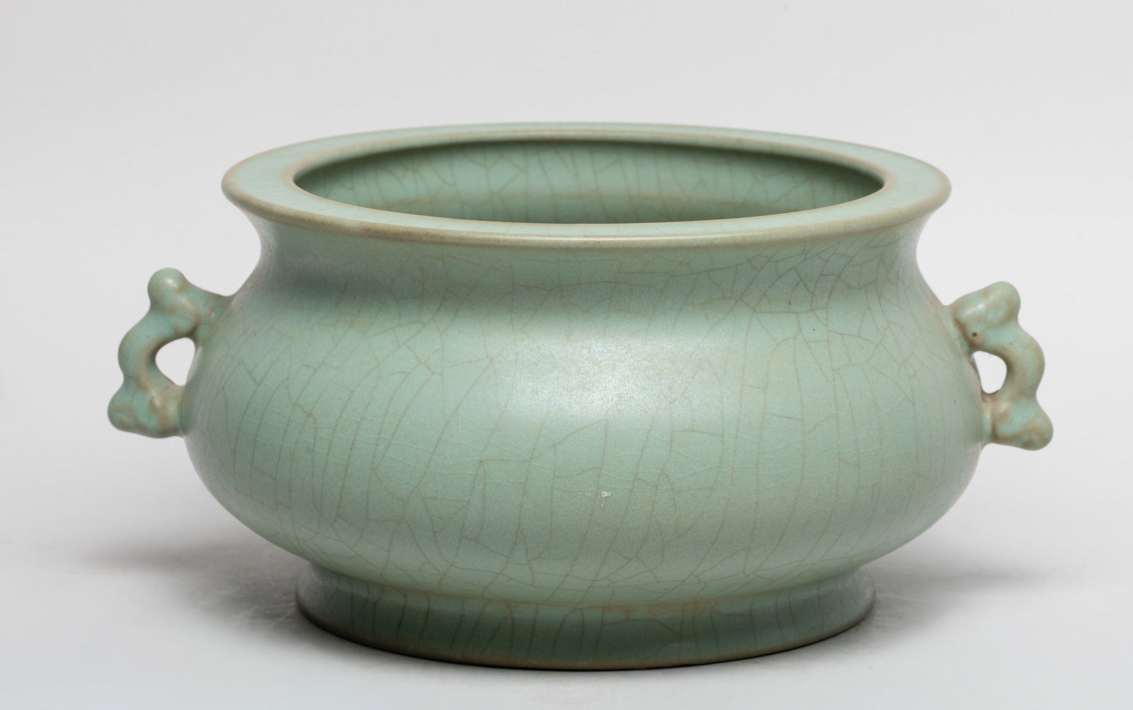 Collectible Chinese Porcelain Censer: Of compressed globular form rising from a splayed foot to a waisted neck, flanked by a pair of stylized handles, overall covered in celadon glaze suffused with a network of crackles. Approx. 9*7.5*4 i