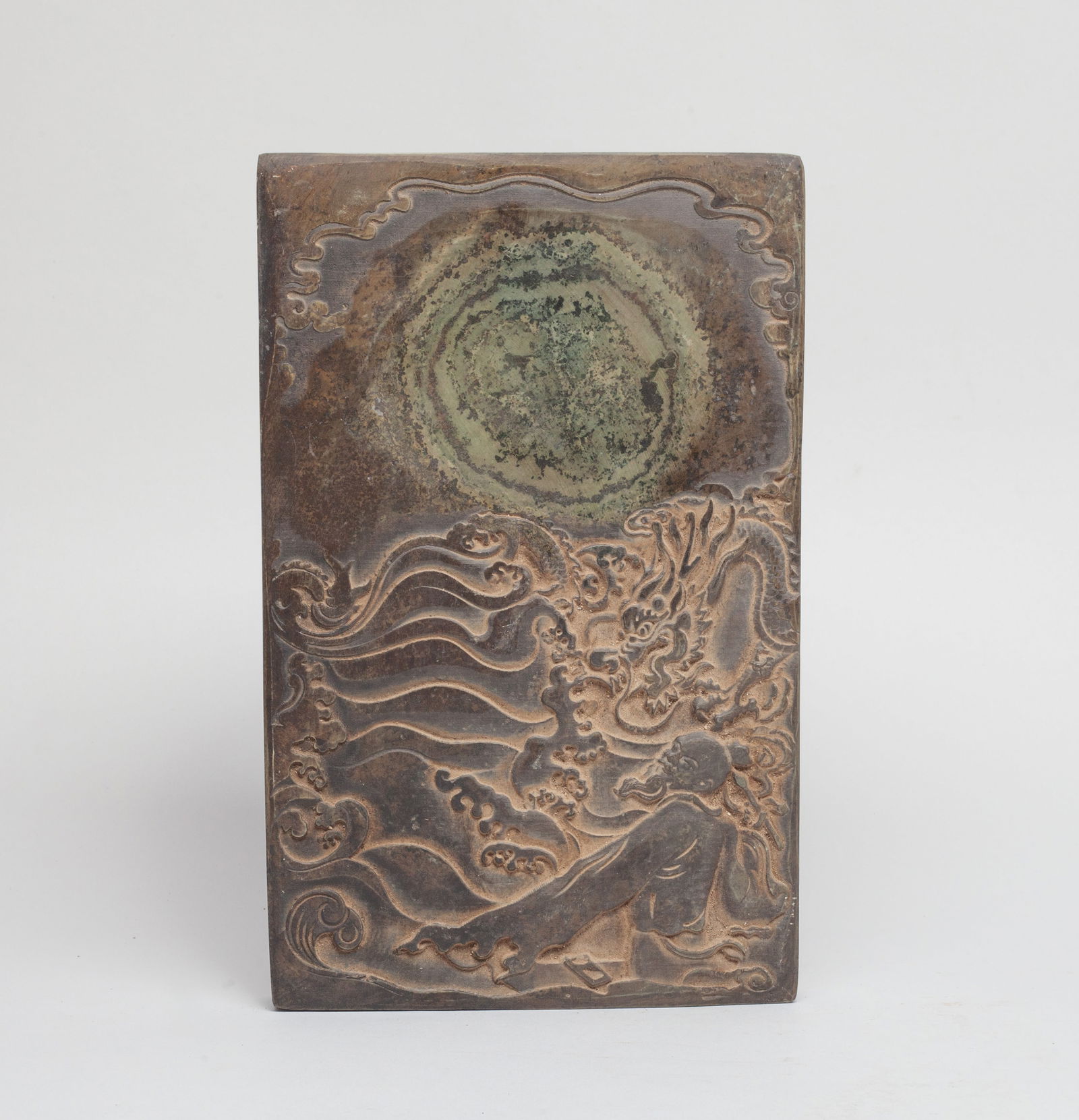 Heavy Chinese Stone Carved Ink Stone: Of rectangular shape, carved with a figure holding a brush pen in hand, facing a dragon and foaming waves, the underside with inscription. Approx. 9*5.6*0.8 inch.