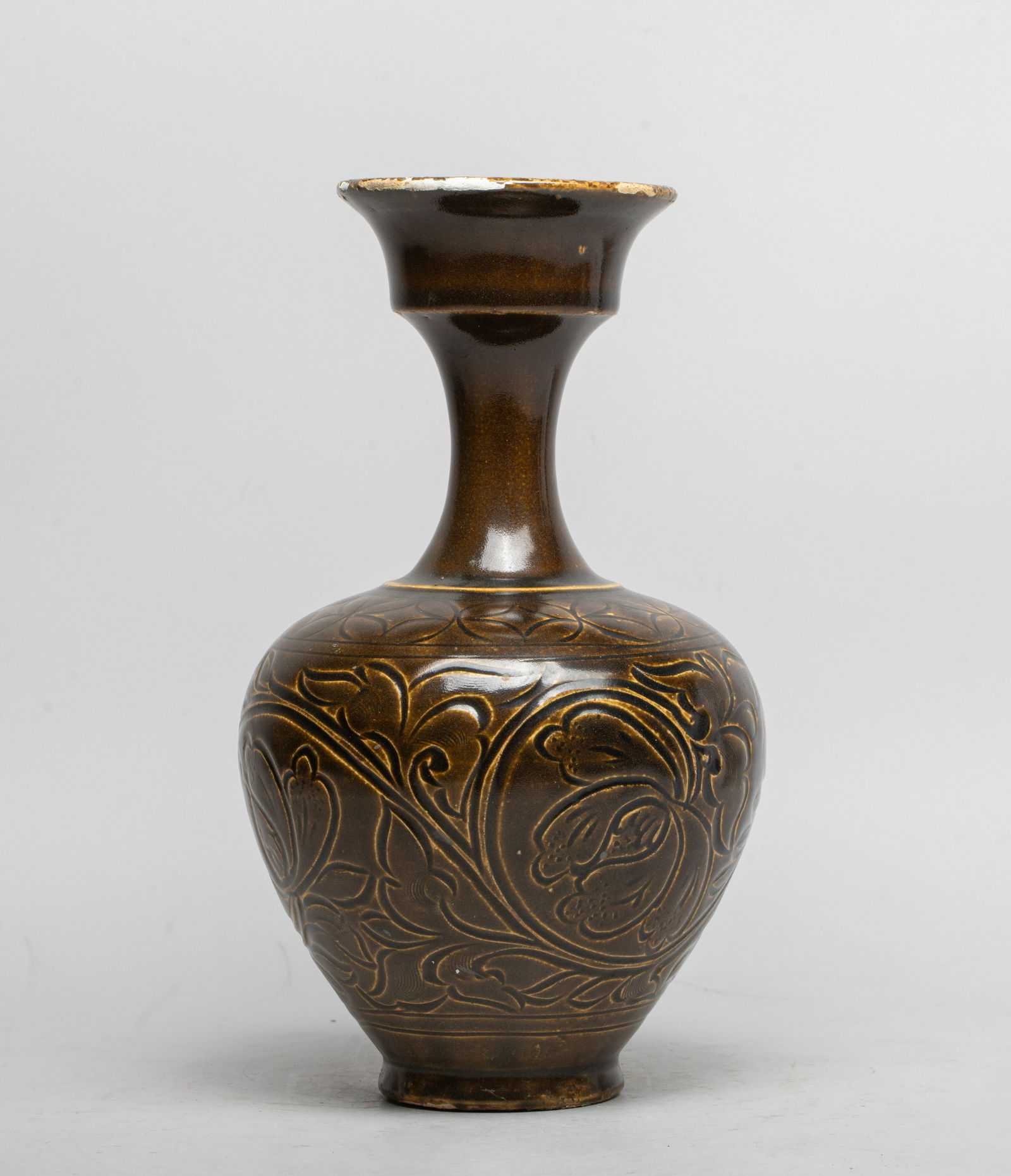 Chinese Yue Stoneware Porcelain Vase: The ovoid body carved with undulating lotus scrolls, under a band of coins, rising to a waisted neck and a flared mouth, covered overall save for the foot in dark olive-brown glaze. Approx. 10.3*5.8 i