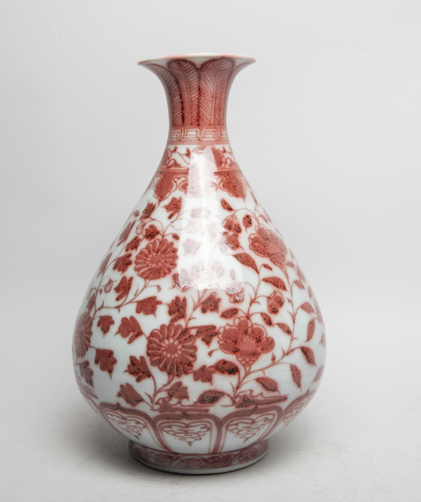 Chinese Export Porcelain Vase: The pear-shaped body rising from a short foot to a waisted neck with a flared rim, the exterior painted in copper-red color with dense leafy lotus foliage between bands of leaves and petals. Approx. 1