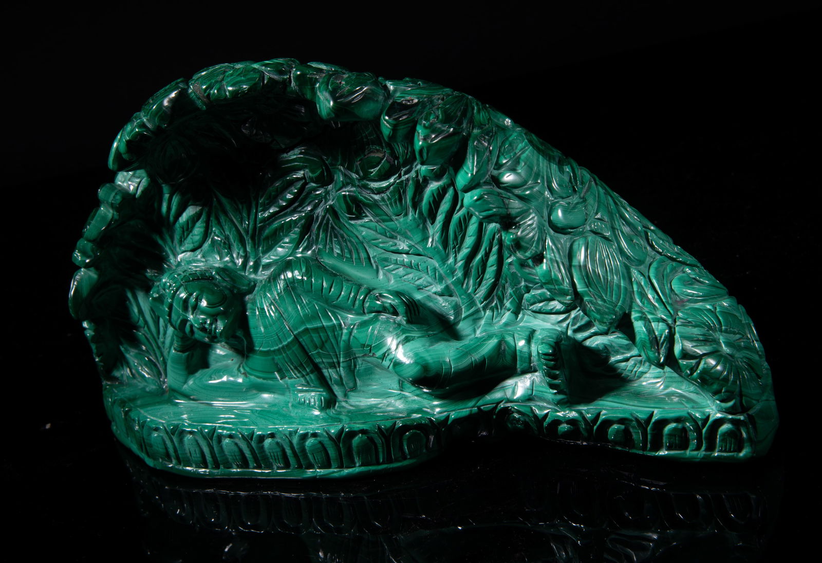 Rare Chinese/ Asian Malachite Buddha Sculpture: The malachite boulder carved with Buddha lying on his side, in front of dense blossoming flowers, the base detailed with a band of lotus petals. Approx. 9*4.7*2.7 inch. The Estate of the Robert. H. Mi