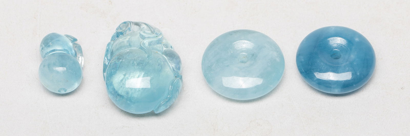 High Quality Chinese Aquamarine Pendants: Set of four high quality aquamarine carved pendants, two of disc shape, one of gourd shape, the other carved with gourd and lingzhi. Approx. 23 gram (total weight), 1.24*0.85*0.52 inch (largest). The